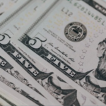 Dólar fecha a R$ 5,12, menor patamar em quase dois anos; Ibovespa recua